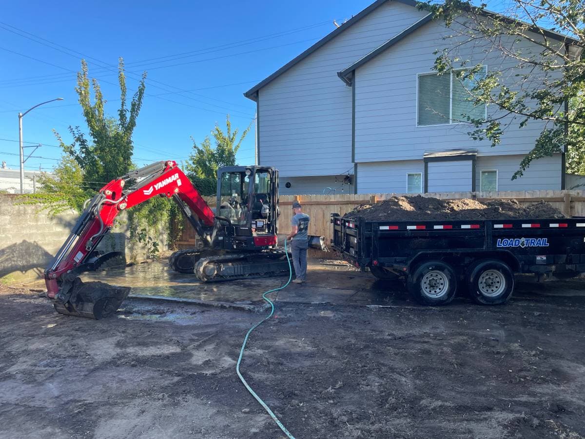 picture of a an excavator and a truck hauling dirt